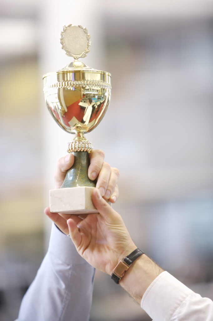 close up of trophy in businessmen s hands 1